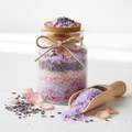 Lavender and rose bath salts in glass jar with dried flowers on white background