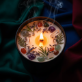 Cedar and sandalwood soy candle with dried herbs and crystals on dark moody background