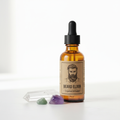 Crystal-infused beard oil in amber glass dropper bottle on white background