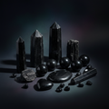 Polished black tourmaline and obsidian crystal set on dark moody background